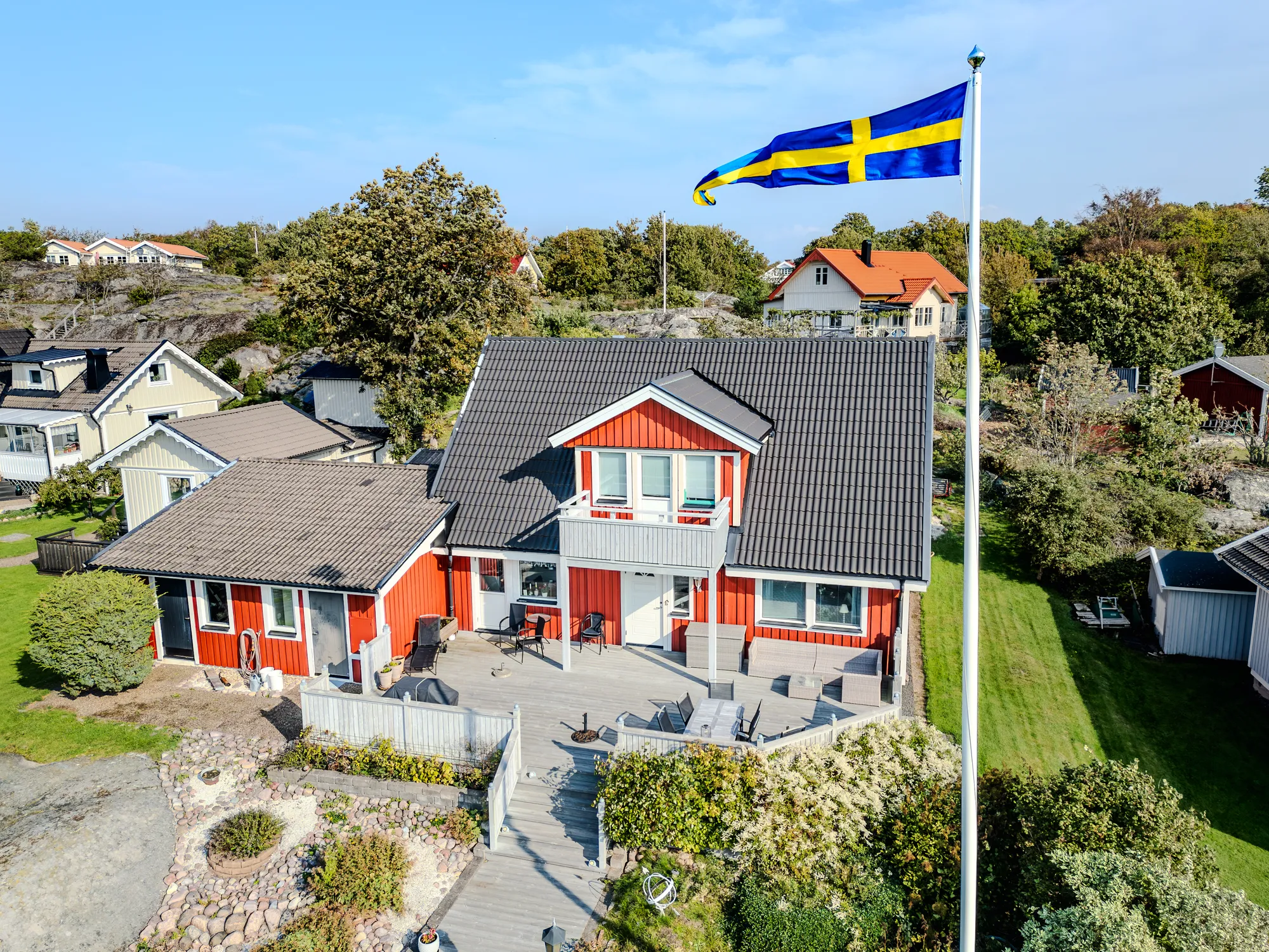 Luftaufnahme eines Einfamilienhauses mit Garten und schwedischer Flagge 