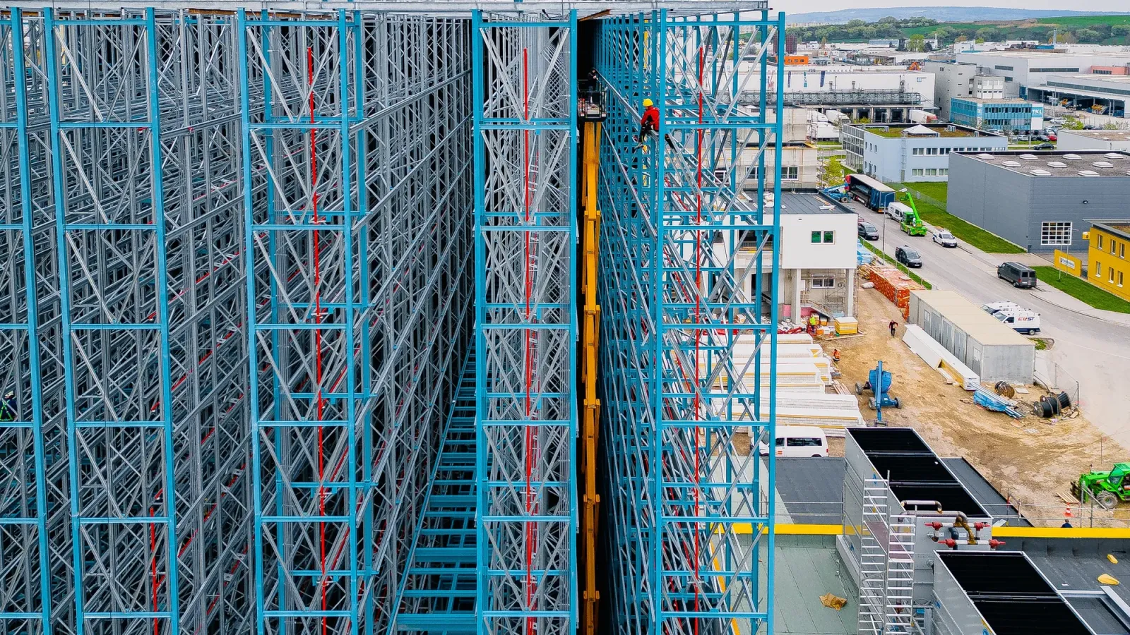 Drohnenaufnahme einer Hochbaustelle mit Stahlkonstruktion und Baukran in Österreich